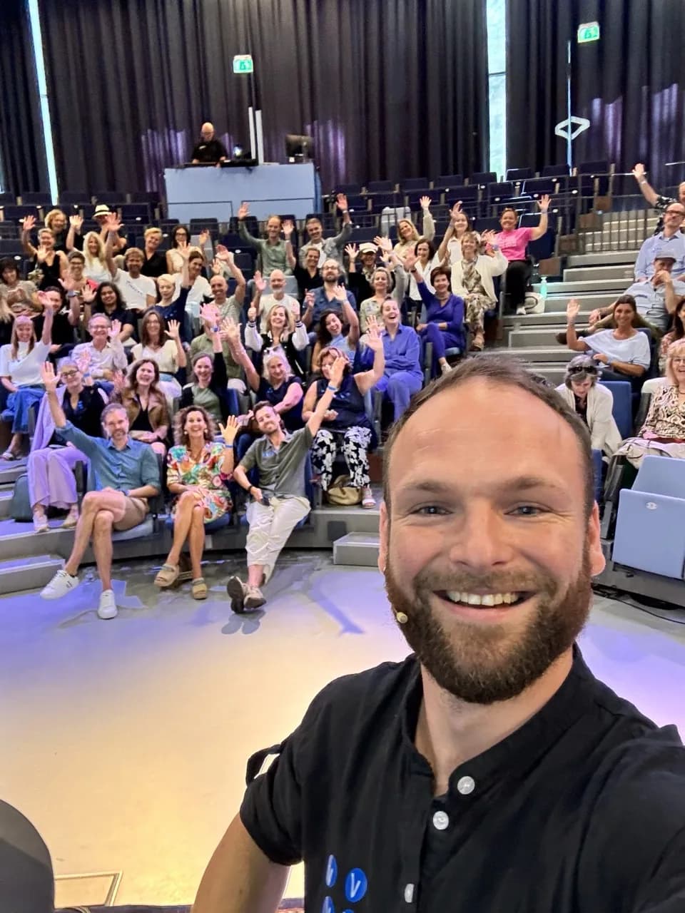 Olaf Lemmens maakt een selfie met een zwaaiende zaal na een AI-lezing